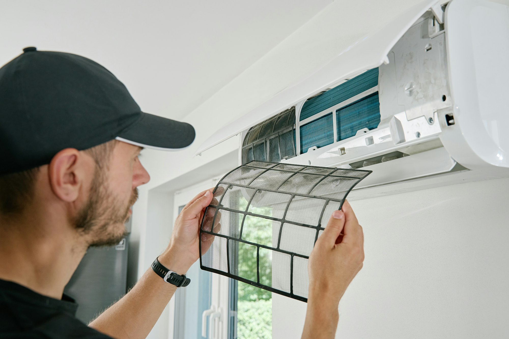 Air conditioner maintenance. Male technician repairing cooling system