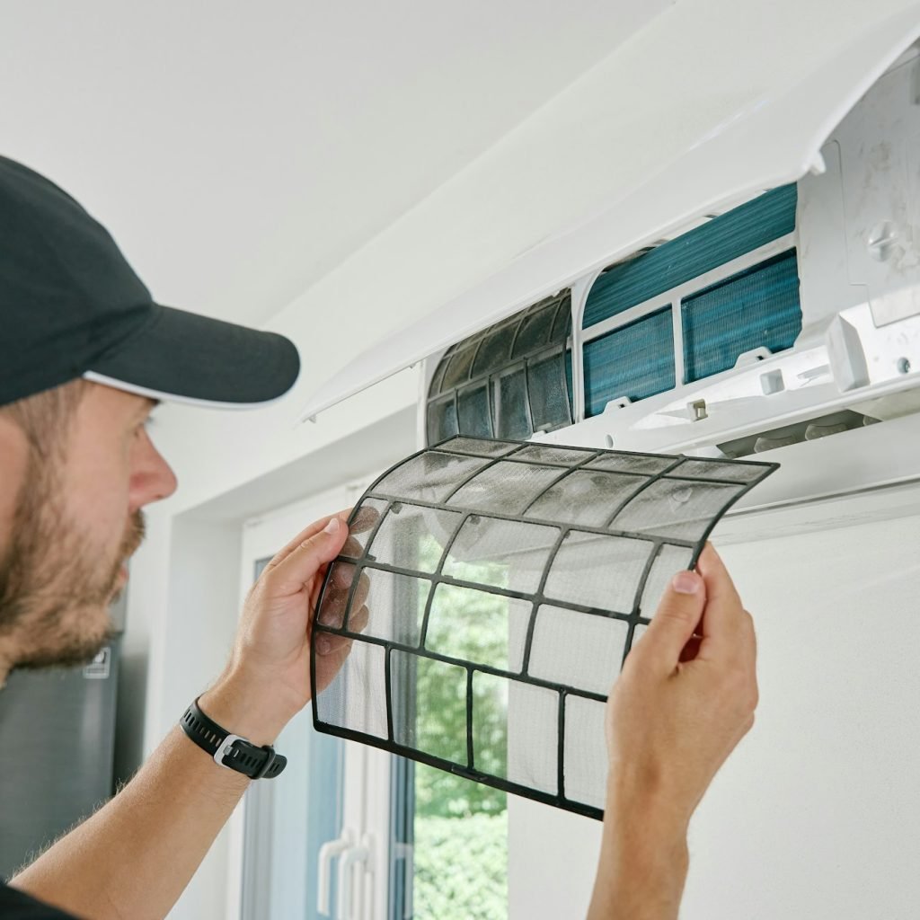 Air conditioner maintenance. Male technician repairing cooling system