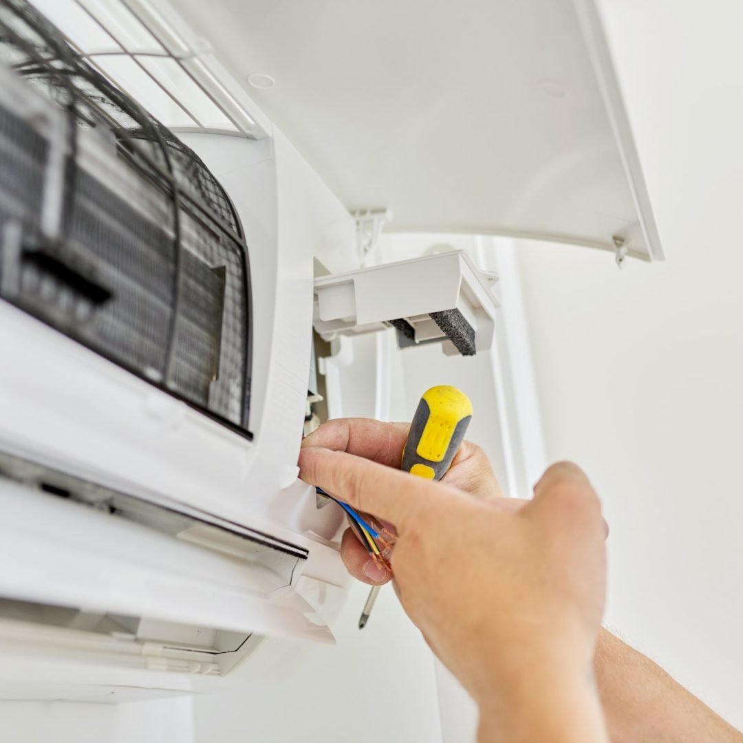 Installing an air conditioner in an apartment office, close-up of an engineer hand