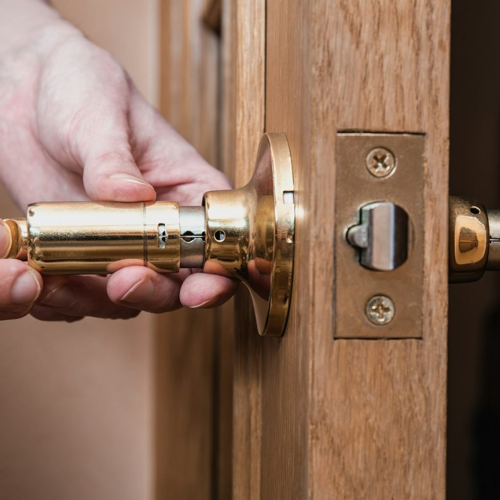 locksmith carpenter fix knob on wooden door by screwdriver for home service reparation.