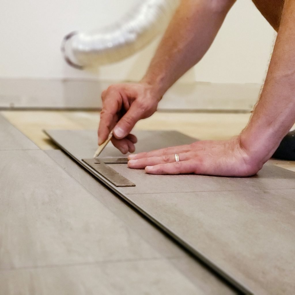 Man's hands holding flooring plank and measuring place to cut for floor installation home improvemen